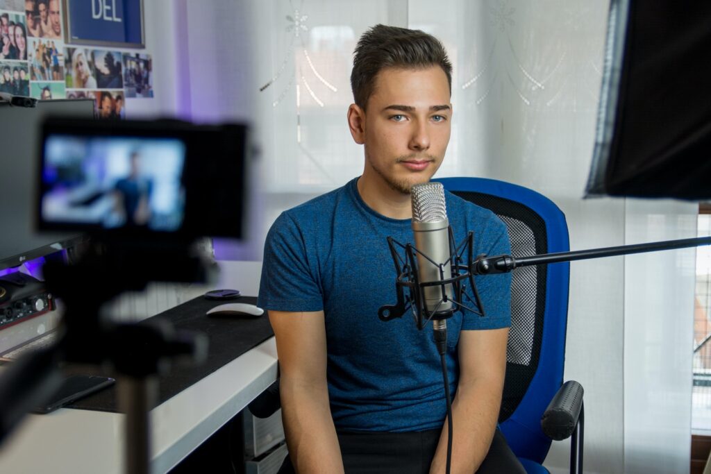 man sitting on chair in front of condenser microphone doing video call to action