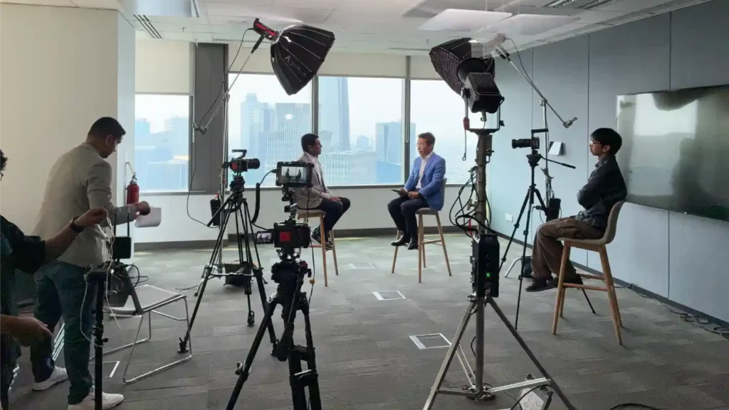 Behind the scenes of a corporate interview setup with camera and lighting crew